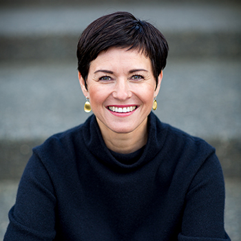 headshot of Kristin Jensen, a white woman with short, dark hair, smiling at the camear