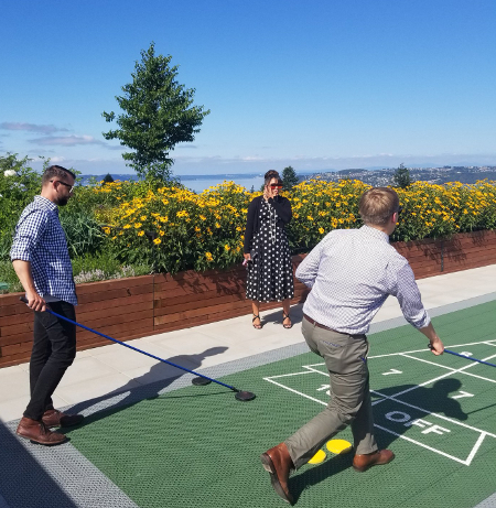 Members play shuffleboard on Proctor Station's rooftop deck